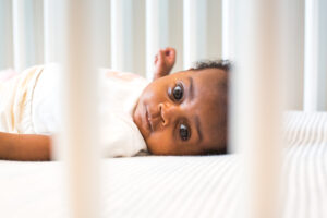 Image of black infant laying in crib